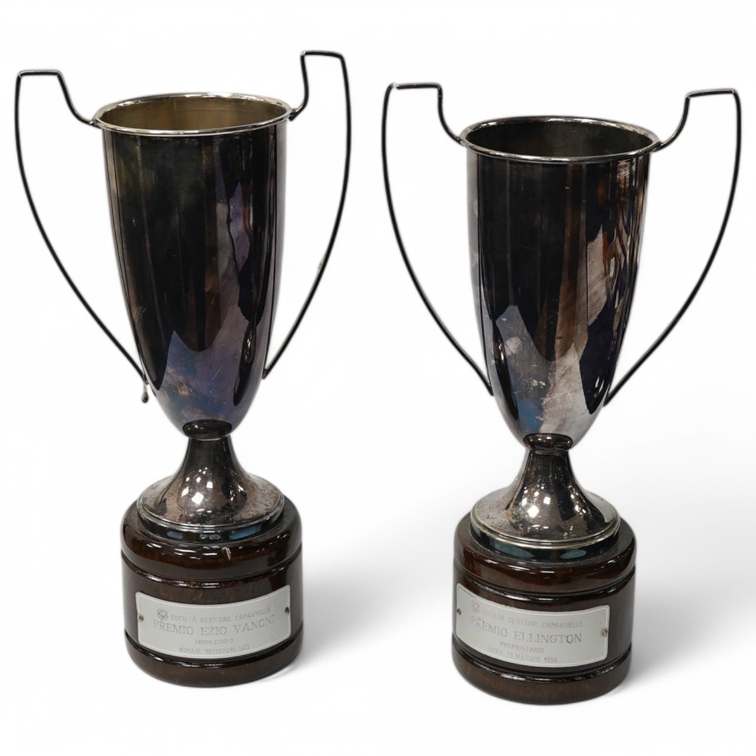 A pair of modern Italian 800 standard white metal two handled trophy cups, fixed on wooden bases, cup heights 23cm. Condition - fair to good